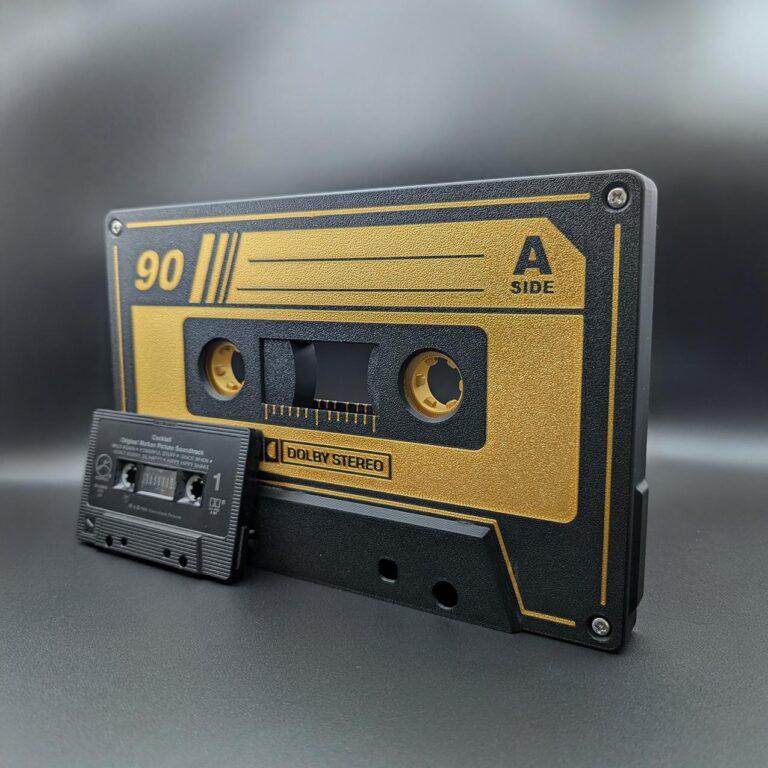 Gigantic retro gold and black cassette tape lightbox, vintage-style music decor with optional LED nightlight, shown next to a standard cassette tape for size reference