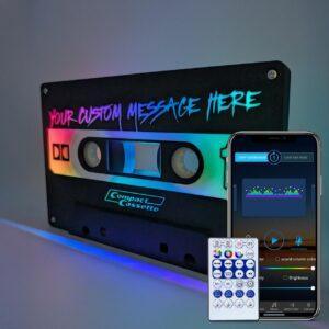 The "Customize your own Audio Cassette Nightlight" is a retro tape-deck styled LED lamp with customizable labels, RGB lighting, EQ-like effects, and effortless control via remote or smartphone app.