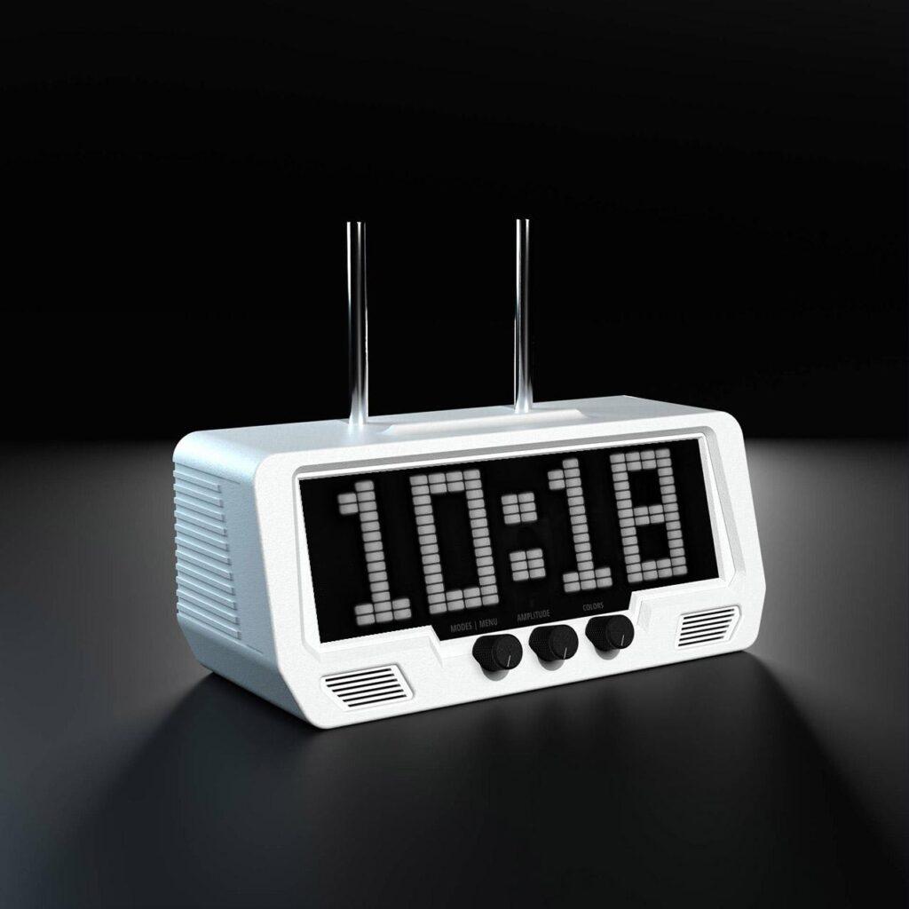 The Audio Visualizer Pro, a white clock radio, displays 10:18 on a black screen. Three audio dials below the LED display highlight its sleek digital interface.