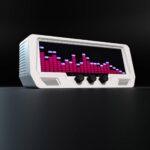 The Audio Visualizer Pro, a white tabletop unit with LED equalizer display, gain knobs, audio dials, and speaker grilles, on black.