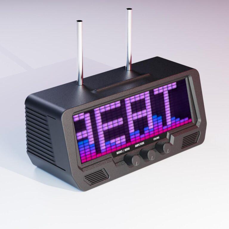 A digital radio receiver with dual antennas and hi-fi speakers displays REAL in bold, colorful block letters on its LED screen.