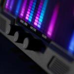 Close-up of an audio equalizer display with RGB LED meter bars and three rotary gain controls labeled Amplitude, emphasizing dynamic audio tuning.