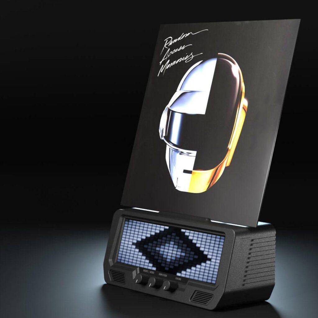A vinyl record with Daft Punk’s Random Access Memories cover stands upright on the Audio Visualizer Pro, a hi-fi speaker with LED VU meters, digital display, volume dials, and EQ sliders.