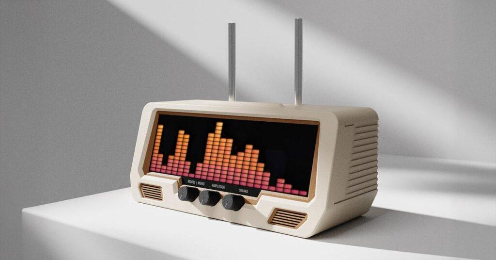 A beige retro-style radio with twin telescopic antennas, equalizer sound bars on its LED display, rests on a white surface in sunlight.