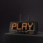 A digital receiver with dual antennas and an LED display shows PLAY in bold block letters, set against a dark, audio tech-inspired background.