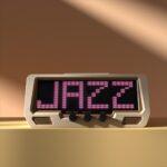 A digital clock-style display shows JAZZ in bold pink pixels, with three audio mixer dials and EQ knobs beneath the LED screen.